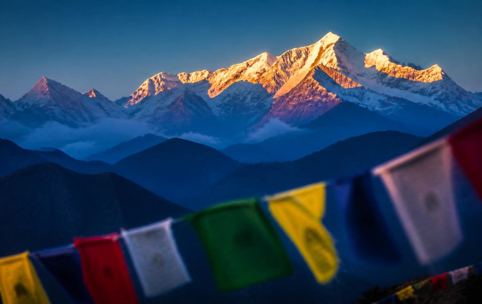 Himalaya-toppen in gouden ochtendlicht met gebedsvlaggen op de voorgrond
